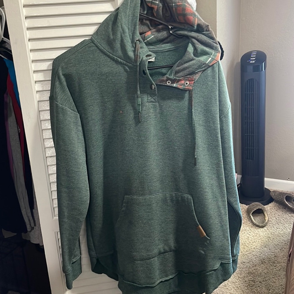 Green hooded sweater. Plain print inside the hood. 3 button snap front. Comfy.